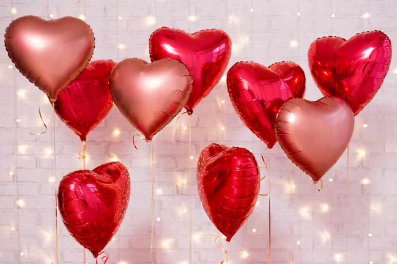 Valentine`s day background - group of red heart shaped balloons over brick wall. Valentine`s day background - group of red heart shaped balloons over brick wall.