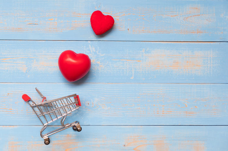 couple red heart shape with mini shopping cart on blue pastel wooden table. love, shopping and Valentine Day Concept couple red heart shape with mini shopping cart on blue pastel wooden table. love, shopping and Valentine Day Concept