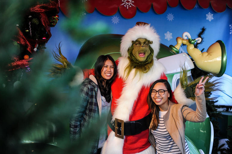 A figure of "Grinch" poses for photos with tourists during the "Grinchmas" celebration at the Universal Studios Hollywood A figure of "Grinch" poses for photos with tourists during the "Grinchmas" celebration at the Universal Studios Hollywood
