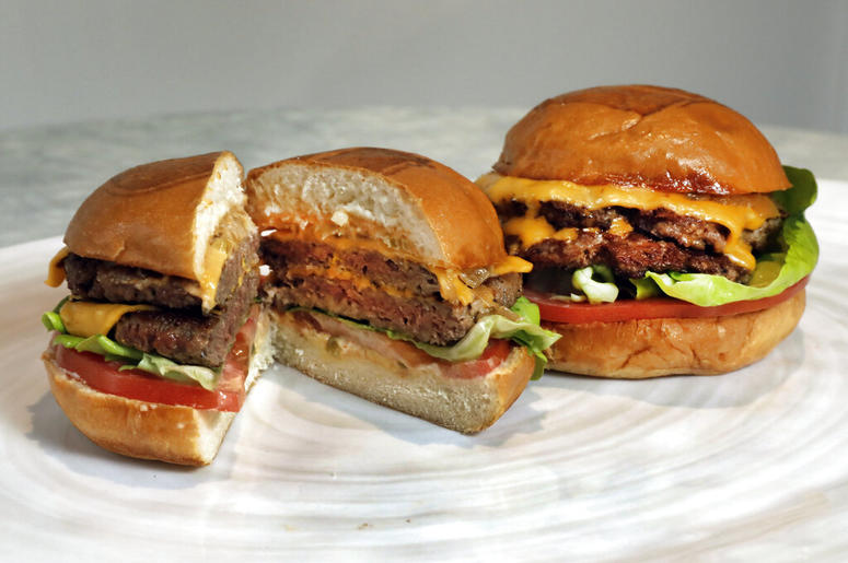 An Original Impossible Burger, left, and a Cali Burger, from Umami Burger, are shown in this photo in New York, Friday, May 3, 2019. A new era of meat alternatives is here, with Beyond Meat becoming the first vegan meat company to go public and Impossible