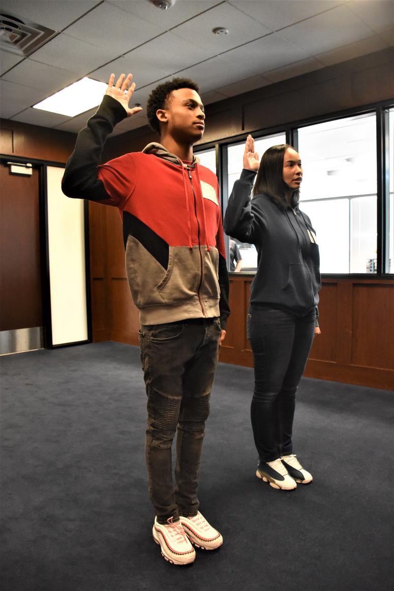 Marquis Butts (left) and his mother, Marva Burns (right), take the oath of enlistment