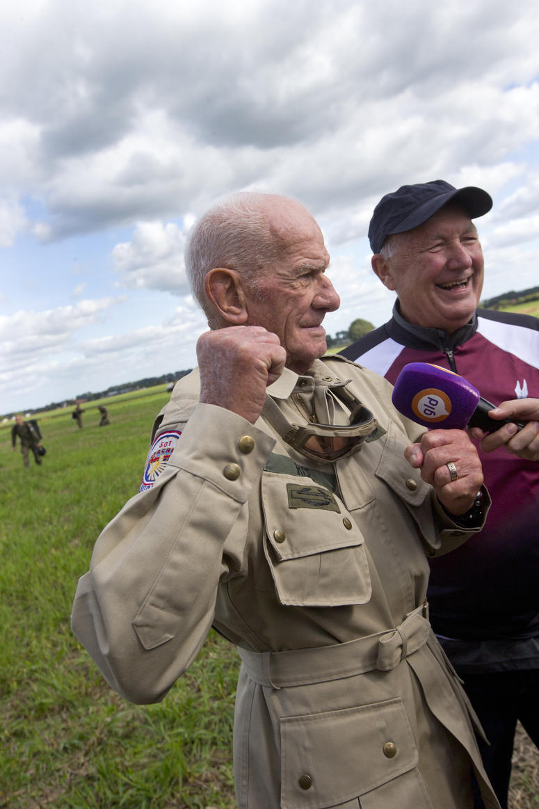 Tom Rice, a 98-year-old American WWII veteran, and U.S. Ambassador Pete Hoekstra, right, talk to journalists after landing with a tandem parachute jump near Groesbeek, Netherlands, Thursday, Sept. 19, 2019. 98 year old veteran talks to reporters after jumping out of plane to commemorate DDay.