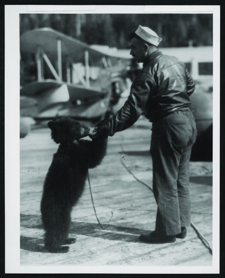 USS Gannet machinist’s mate turned bear keeper feeds his new charge. NavyBearUSSGannet