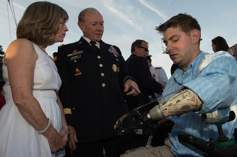 Gen. Martin E. Dempsey, chairman of the Joint Chiefs of Staff, and his wife Deanie, talk with John Peck, on the West Lawn of the U.S. Capitol in Washington, D.C., May 25, 2014.