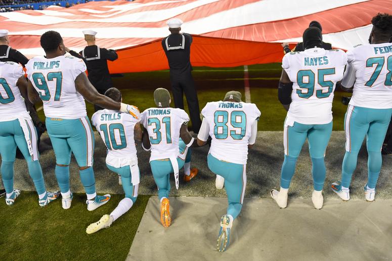 Nov 13, 2017; Charlotte, NC, USA; Miami Dolphins players kneel during the national anthem at Bank of America Stadium