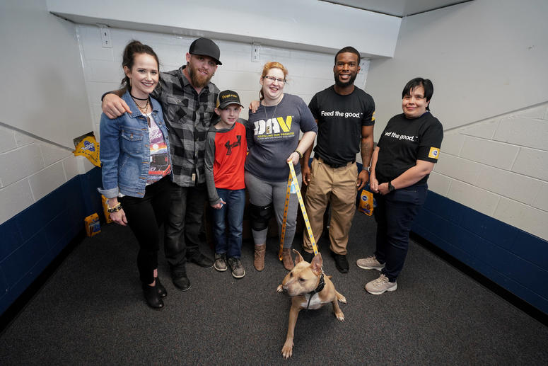 Brantley Gilbert (2nd from Left) provides a veteran with a comfort dog during his current tour.