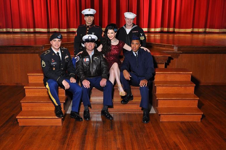 Gina Elise, founder of Pin-Ups For Vets poses with members of each branch of the military