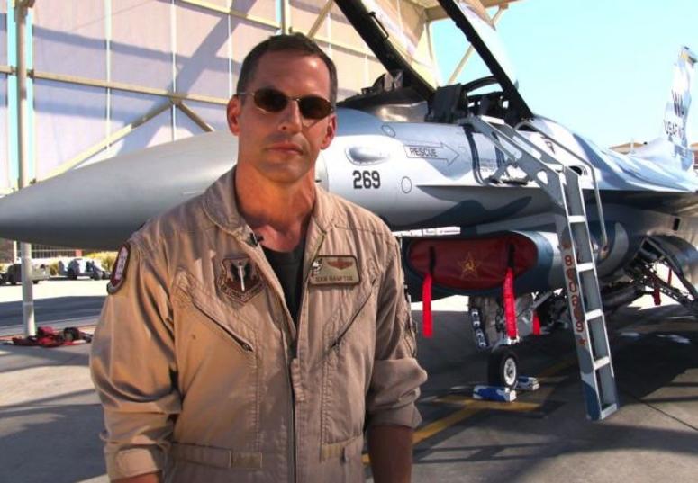 Dan Hampton, US Air Force fighter pilot standing in front of an F-16 fighter jet.