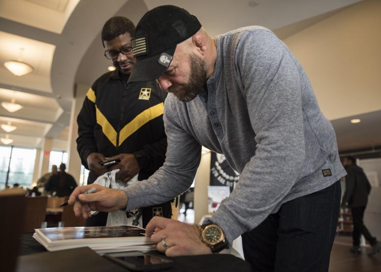 Mixed martial arts fighter Randy Couture signs a photo for a Soldier Jan. 26, 2017 during a visit to Naval Support Activity Bethesda. Five-time UFC champion Couture served in the Army from 1982-1988.