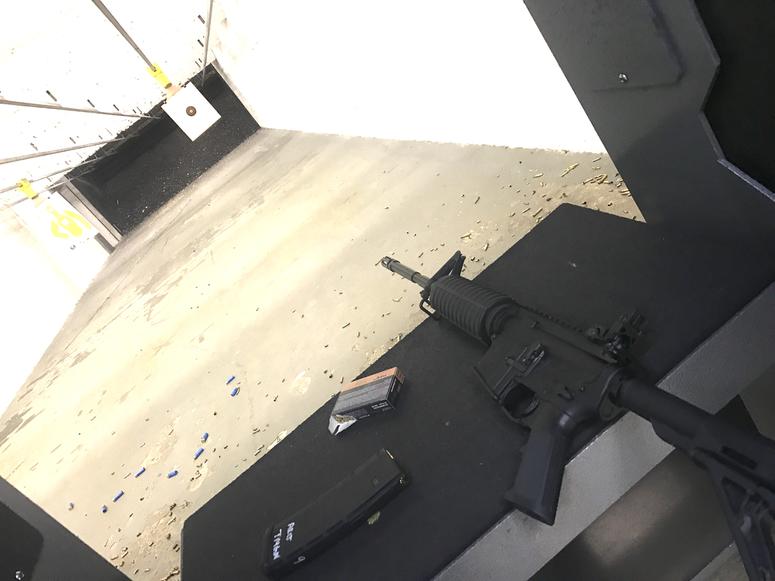 The AR-15, magazine, rounds and the lane inside the firing range.
