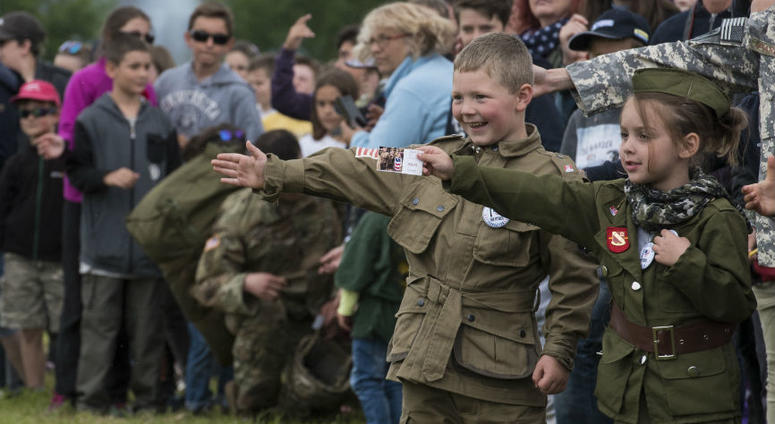 A French boy, dressed in a mock WWII-era uniform displaying the American flag, Canadian flag and an illustrated pin stating “I heart our veterans." Over 1,000 U.S. paratroopers participate in largest airborne operation since WWII to commemorate 75th anniversary of D-Day.