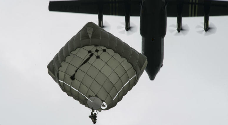 A static-line paratrooper prepares to land as a U.S. Air Force C-130J Super Hercules, assigned to the 37th Airlift Squadron, Ramstein Air Base. Over 1,000 U.S. paratroopers participate in largest airborne operation since WWII to commemorate 75th anniversary of D-Day.