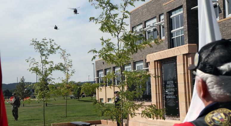 A member of the Patriot Riders stands watch as three Blackhawk helicopters complete a flyover near South Dakota Army National Guard Joint Force Headquarters on September 8, 2018. The flyover was part of the dedication of a new memorial plaza.