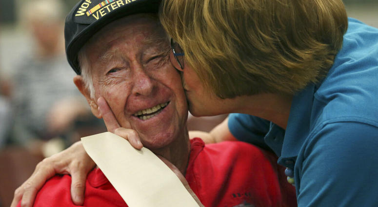 Alamo Honor Flights volunteer Elizabeth Montalvo kisses World War II veteran E.W. King, 94, before a ceremony