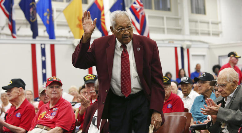 Tuskegee Airmen James L. Bynum, 98, waves as he is introduced during a ceremony at Joint Base San Antonio-Fort Sam Houston