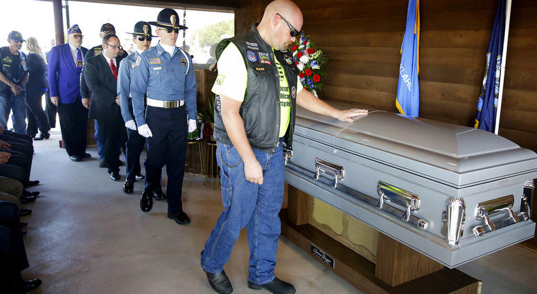 A mourner touches the casket of World War II veteran Herman White