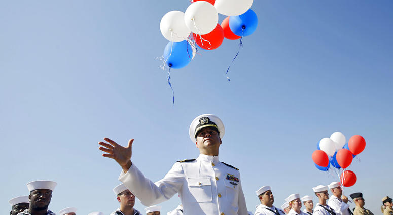 Navy Lieutenant Luke Hosman releases balloons during a funeral service for World War II veteran Herman White