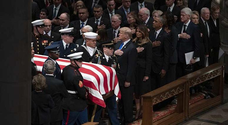 The flag-draped casket of former President George H.W. Bush is carried by a military honor guard past former President George W. Bush and wife Laura Bush, President Donald Trump, first lady Melania Trump, former President Barack Obama, Michelle Obama, for