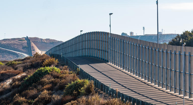 A section of the international border wall between San Diego, California and Tijuana, Mexico, as it travels over rolling hills. BorderWall