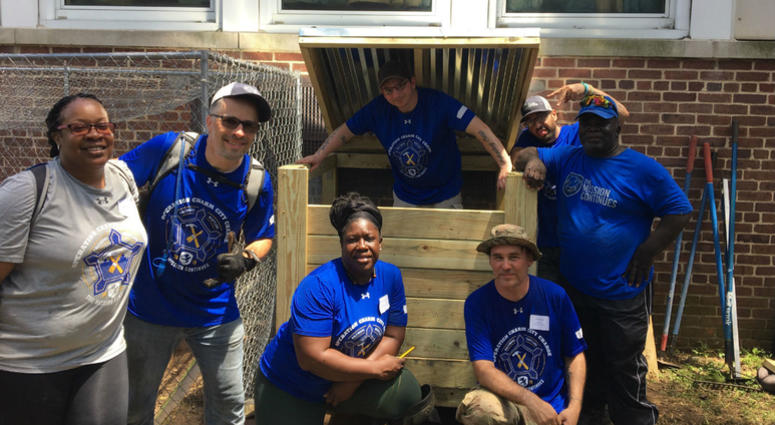 Jacob Kratavil and his team pose with the compost bin they built at Ben Franklin High School. 80 veterans from The Mission Continues at Ben Franklin High School in Baltimore.