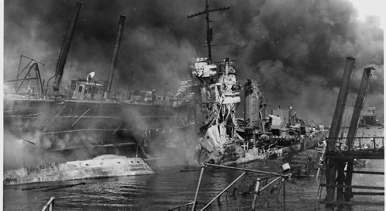 Naval photograph documenting the Japanese attack on Pearl Harbor, Hawaii which initiated US participation in World War II. Navy's caption: The twisted remains of the destroyer USS SHAW burning in floating drydock at Pearl Harbor after the "sneak Japanese