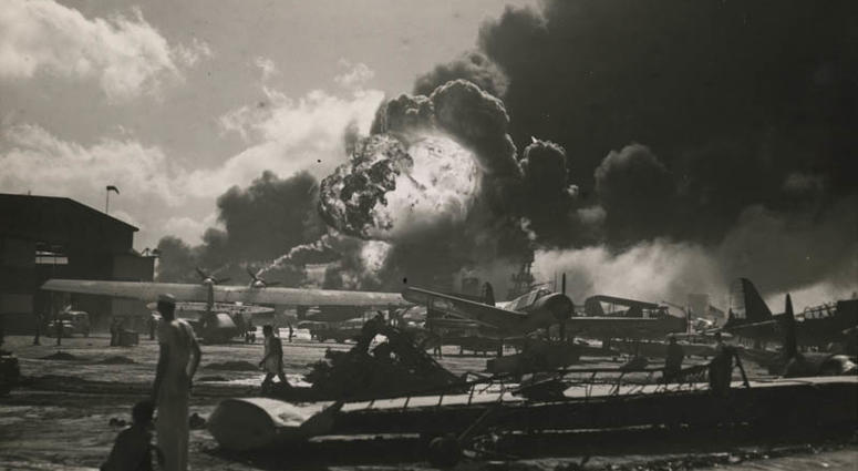 This is the wreckage-strewn Naval Air Station at Pearl Harbor following one of the Japanese sneak attacks on the morning of December 7, 1941. In the background, an explosion sends a mass of flames and smoke high into the sky." Archivist note: Aside fro