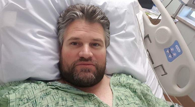 Brian Tally in a hospital bed being treated for inexplicable back pain