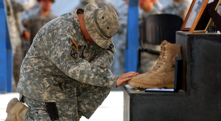 A Soldier pays his respects to Staff Sgt. Travis Atkins, who was killed June 1 by a suicide bomber near Sadr Al-Yusufiyah, Iraq, at a memorial ceremony held June 7 at Camp Striker. Atkins was on a patrol with his unit, Company D, 2nd Battalion, 14th Infan Staff Sgt. Travis Atkins will recieve the Medal of Honor