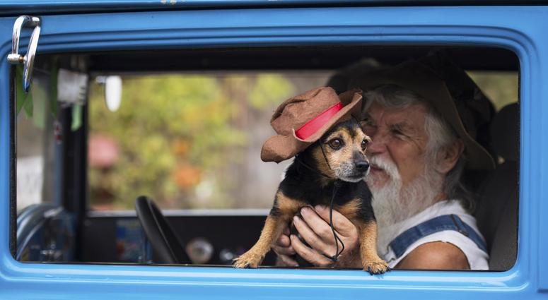 robert Perry and his dog, Black Jack, sit in their car.