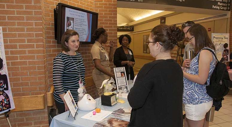 Portsmouth, Va. (June 9, 2017) Heather McFarland, left, an outpatient lactation consultant with the Pediatrics Clinic, speaks with a patient about lactation consultant services during the Pregnancy Fair at Naval Medical Center Portsmouth. The Women’s Hea