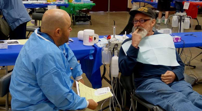 Veteran Cliff Emerson consults with dentist Maurice Trusas at the North Valley Stand Down.