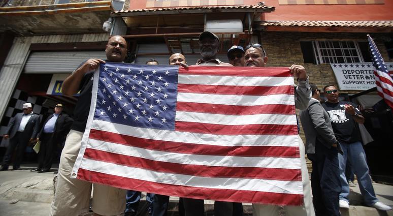 Deported vets holding a U.S. flag outside the Deported Veterans office on June 3, 2017 as seven members of Congress visit the Deported Veterans Support House in Tijuana, Mexico. Deported