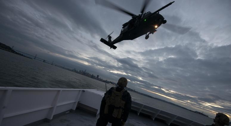 Members of Coast Guard Maritime Security Response Team West await extraction by the 129th Rescue Wing in day- and night-time fast-rope training onto the deck of the Hornblower Spirit in San Francisco Bay, December 5, 2018.