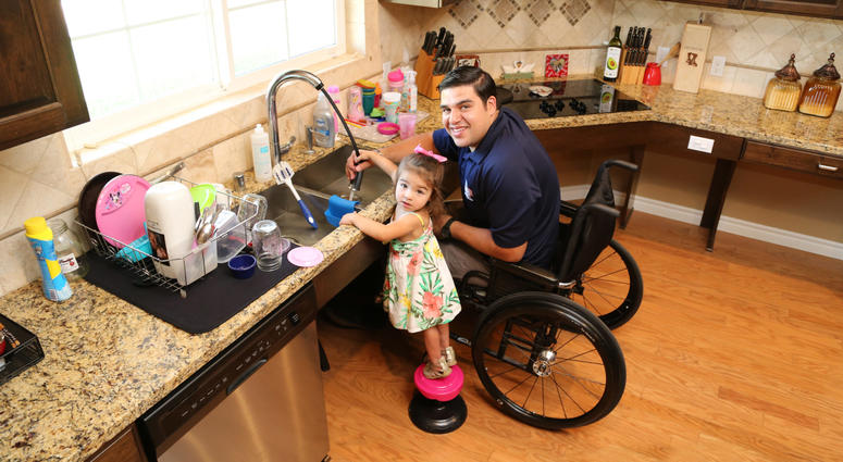 Homes for Our Troops provides adapted homes, free of charge, to severely combat wounded veterans A wounded combat veteran who received a house from Homes For Our Troops washes dishes with his daughter