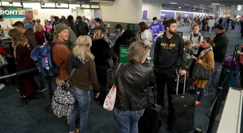 People wait in line at the Frontier Airlines ticket area to check their bags. Thanksgiving Day travelers flocked to Mitchell International Airport in Milwaukee, Wisconsin on Nov. 21, 2018.