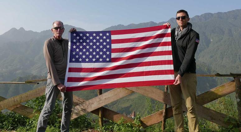 Rich Rice (left) and Jason McCarthy (right) pose with an American flag in Vietnam