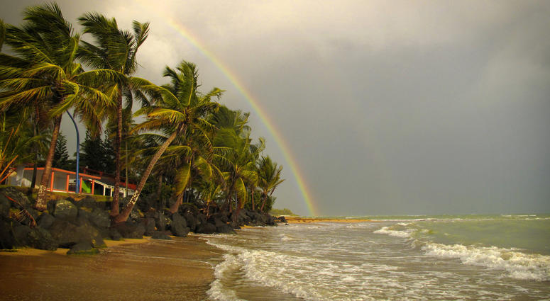 A rainbow forms at Luquillo Beach in Puerto Rico. If this were your home, you wouldn’t pay property tax for 10 years