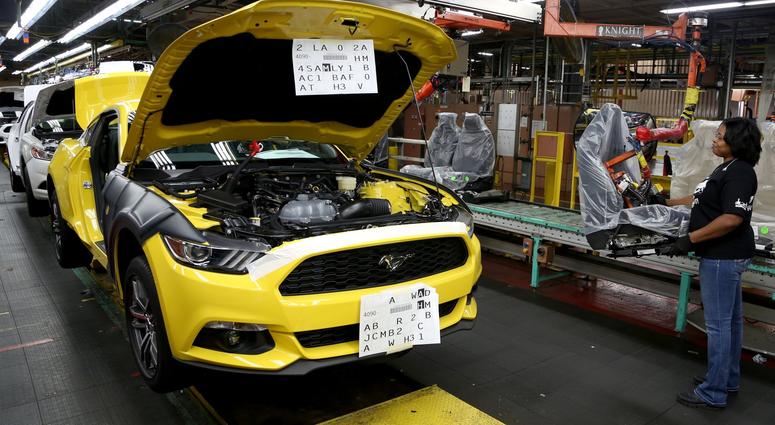 Assembler Karla Browen, 41, of Taylor, Mich., waits for the production line to start up again so she can install the driver's seat inside a 2015 Ford Mustang GT at the Ford Flat Rock Assembly Plant in Flat Rock, Mich.