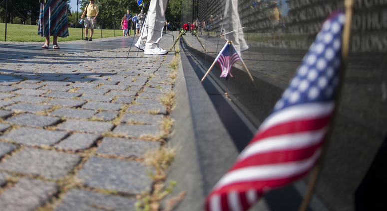 Caption: A Vietnam Veterans Memorial docent makes a rubbing for the family of Spc. 4 Donald P. Sloat who was posthumously awarded the Medal of Honor