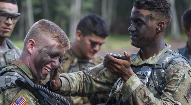 An infantryman from covers fellow soldier with camouflage paint. They preparing for a live fire exercise during a National Guard Bureau-sponsored exercise uniting approximately 5,000 service members from 13 states and five coalition countries