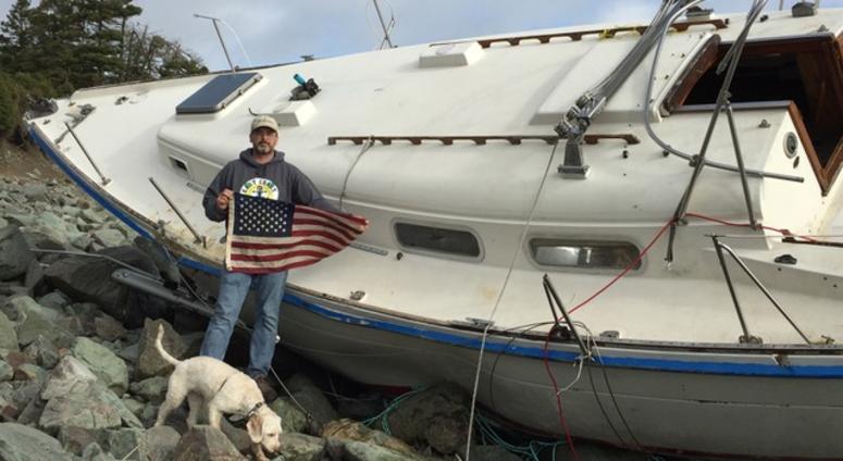 Retired Sailor Steve Smith with an American flag recovered from the shipwrecked Liberty