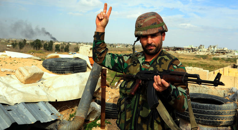 A Syrian soldier flashes a victory sign in Damascus' Eastern Ghouta countryside, Syria, on March 10, 2018.