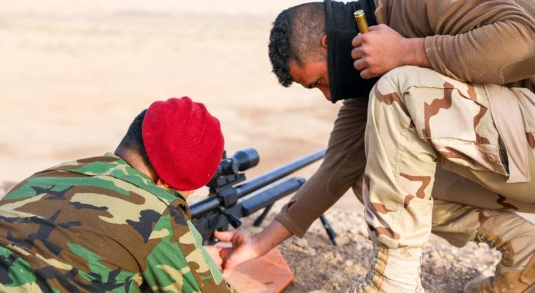 An Iraqi security forces member assists a fellow classmate in immediate action for the Steyr HS .50 rifle during a familiarization fire portion of an advanced marksman course at Camp Taji, Iraq, Jan. 24, 2018. Camp Taji is one of four Combined Joint Task training
