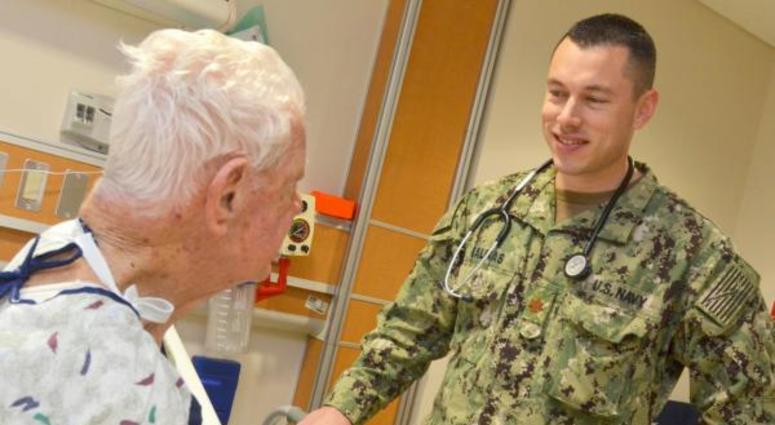 JACKSONVILLE, Fla. (April 3, 2018) Lt. Cmdr. Dagoberto Salinas, a clinical nurse specialist at Naval Hospital Jacksonville, checks on a World War II veteran in the multi-service unit.