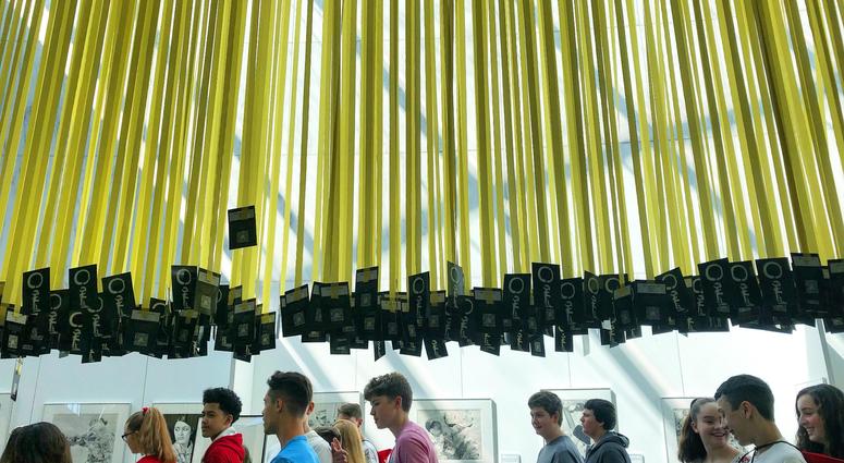 People walk past yellow ribbons for each of the 6,964 service members killed since 9/11 hanging in the Women In Military Service For America Memorial in Arlington National Cemetery. MindfulMemorialDay1