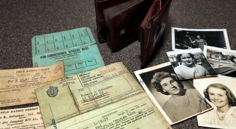 In this August 20, 2018 photo, the lost wallet of Robert McCusker, a war veteran who served in World War II and Korea, is displayed with its contents on a kitchen table in Dover, N.H. McCusker lost his wallet almost 65 years ago in France.