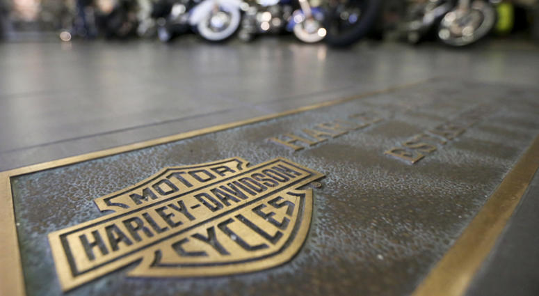 AP18176411243842 In this April 26, 2017, file photo, rows of motorcycles are behind a bronze plate with corporate information on the showroom floor at a Harley-Davidson dealership in Glenshaw, Pa. Harley-Davidson, facing rising costs from new tariffs, will begin shifting