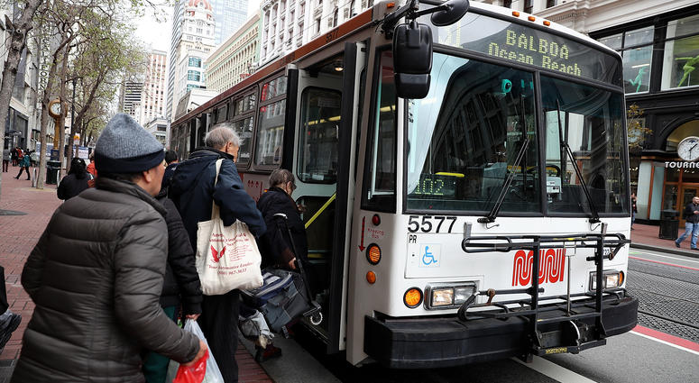 assengers board a MUNI bus on March 21, 2018 in San Francisco, California. assengers board a MUNI bus on March 21, 2018 in San Francisco, California.
