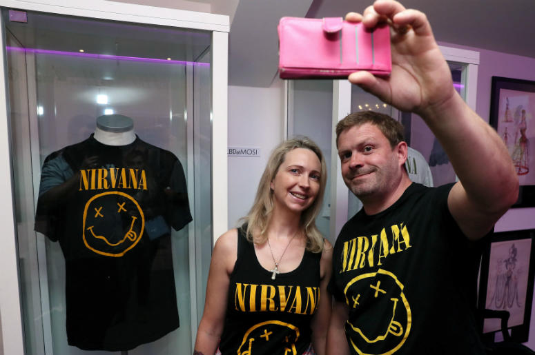 Nirvana fans Tanya and Dave Deegan, from Dublin, take a picture alongside Kurt Cobain's Nirvana smiley face t-shirt at the opening of the 'Growing Up Kurt' exhibition on the life of the Nirvana frontman, at the museum of Style Icons in Newbridge, Ireland. Nirvana fans Tanya and Dave Deegan, from Dublin, take a picture alongside Kurt Cobain's Nirvana smiley face t-shirt at the opening of the 'Growing Up Kurt' exhibition on the life of the Nirvana frontman, at the museum of Style Icons in Newbridge, Ireland.