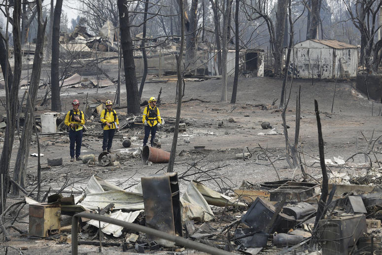 San Bernardino County Fire department firefighters assess the damage to a neighborhood in the aftermath of a wildfire, Sunday, July 29, 2018, in Keswick, Calif. DO NOT USE